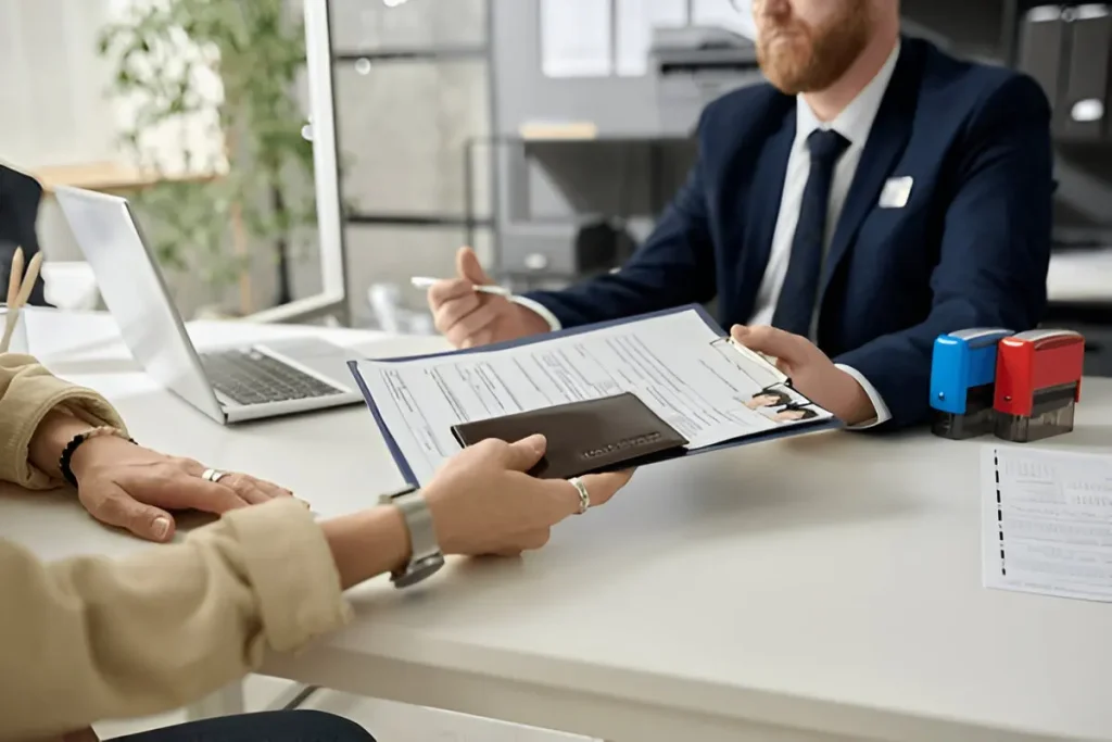 Consumer signing vehicle paperwork with a professional, symbolizing car purchase contracts and potential auto fraud issues.