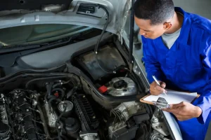 Mechanic servicing a car engine, lemonlawassist