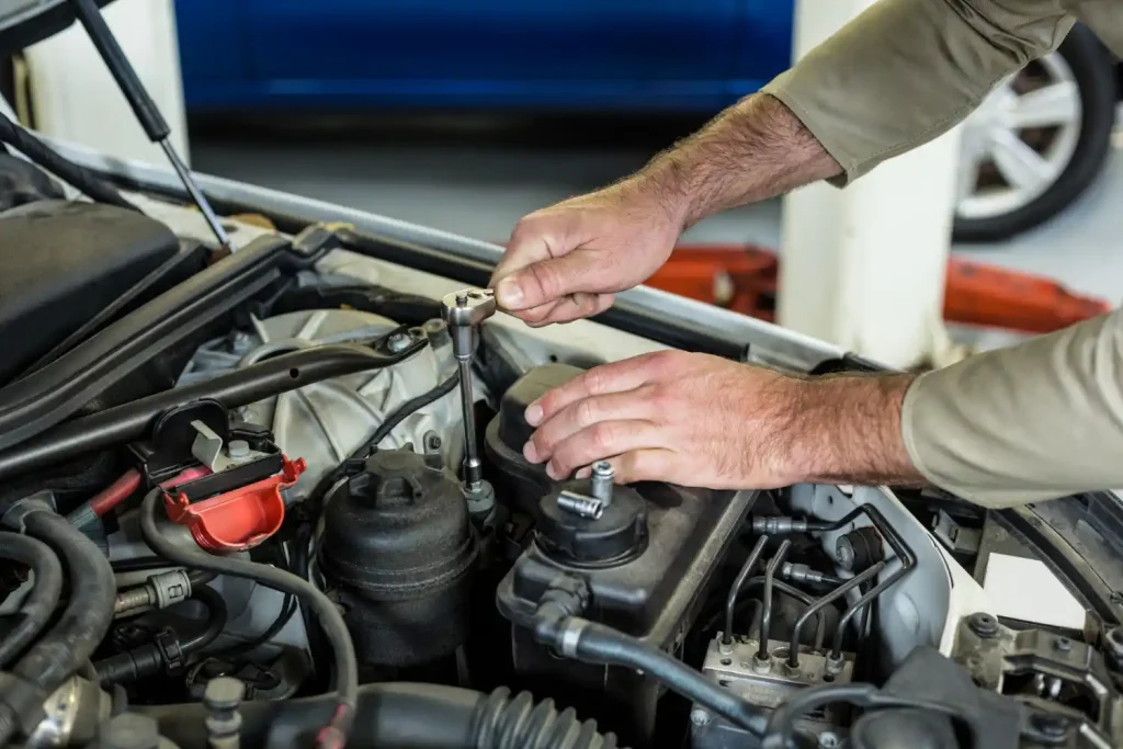 Hands of mechanic servicing a car, lemonlawassist