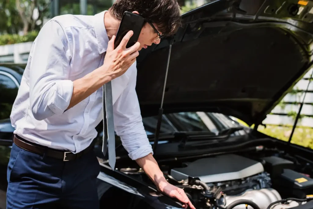 Man calling for help to fix his car, lemonlawassist