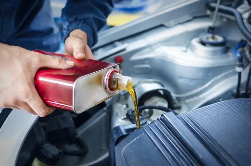Mechanic changing engine oil on car vehicle, lemonlawassist