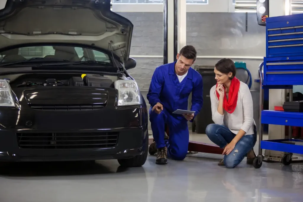 Mechanic showing customer the problem with car, lemonlawassist