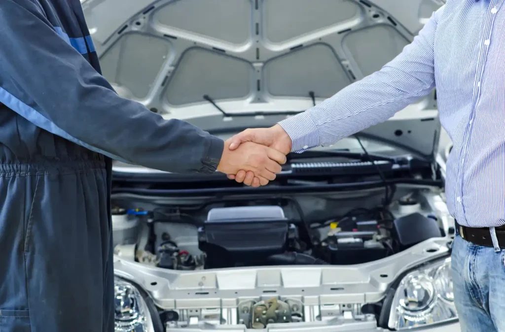 Car mechanic and customer shaking hands, lemonlawasssit