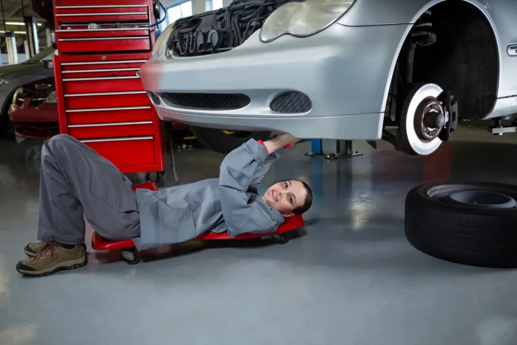 Female mechanic repairing a car bumber, lemonlawassist