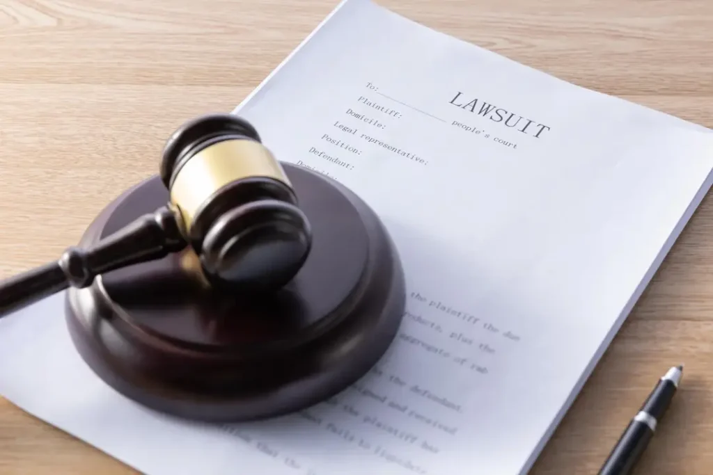 High angle shot of a gavel and lawsuit papers on a wooden surface, lemonlawassist