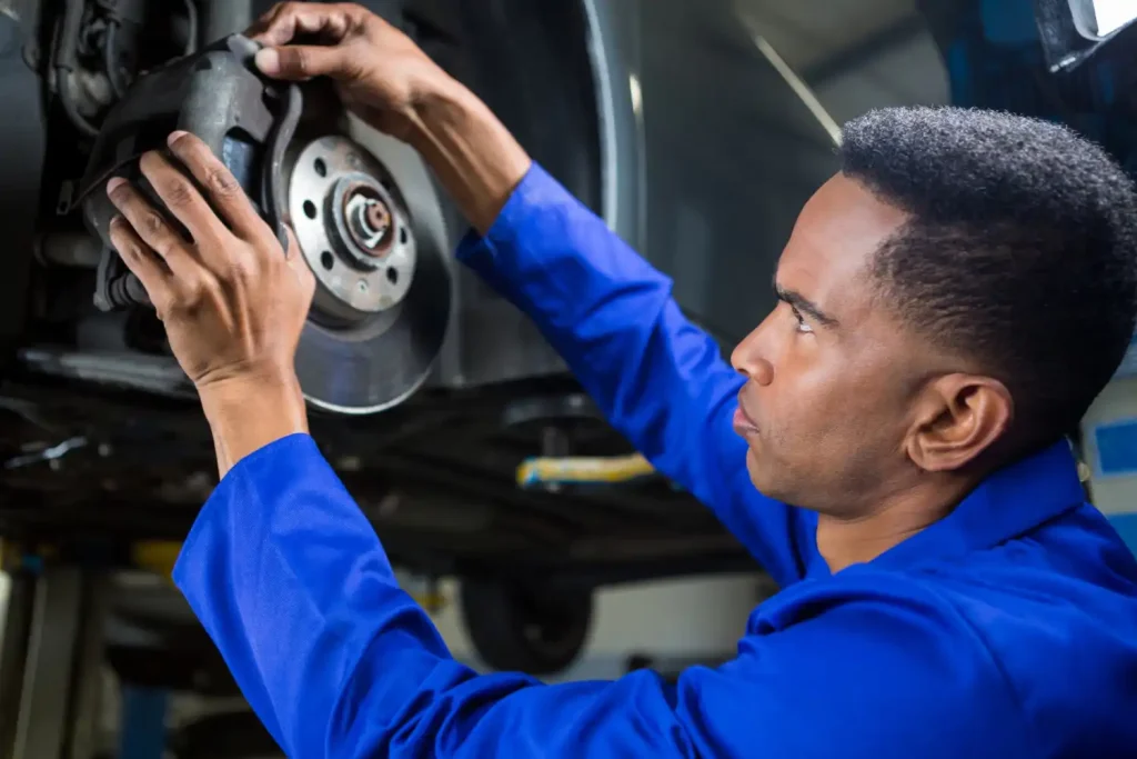 Mechanic fixing car brake, lemonlawassist