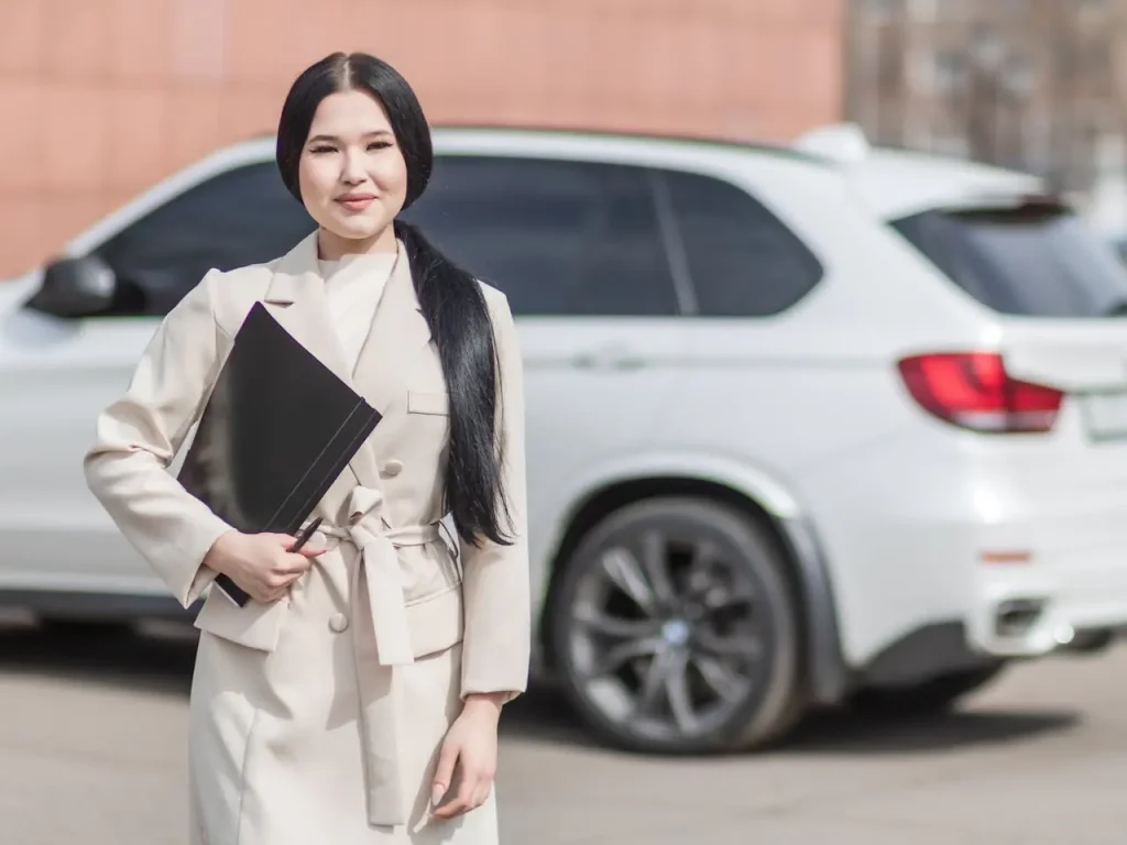 Woman in beige corporate clothes holding black folder, lemonlawassist