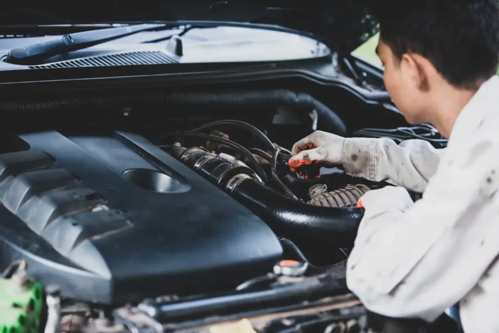 Car repairman wearing a white uniform standing and holding a wrench, lemonlawassist