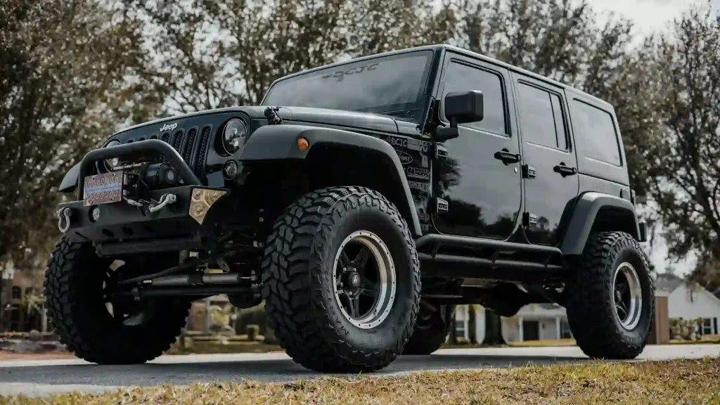 Black Jeep Wrangler, Heavily Modified For Off Road Use. The Jeep Has Large Off Road Tires, A Custom Front Bumper