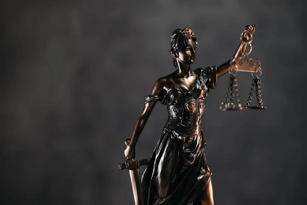 Bronze statue of Lady Justice holding scales and a sword, symbolizing fairness and impartiality in law ,lemonlawassist