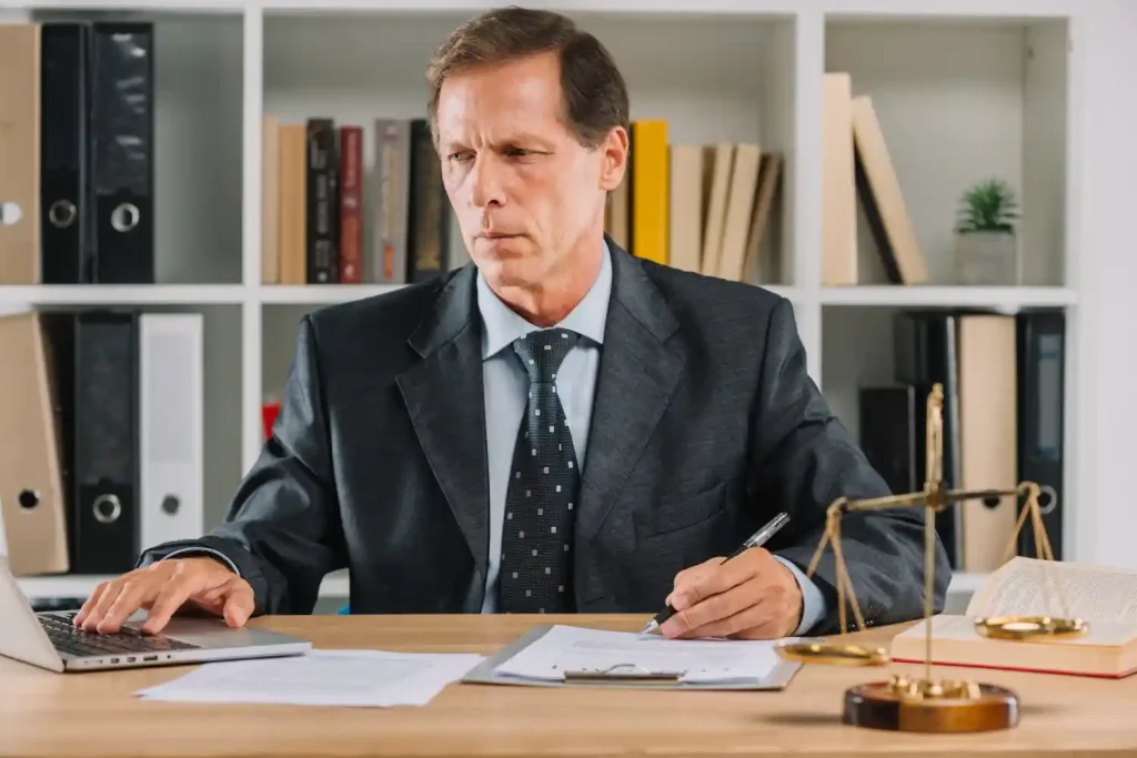 Lawyer using laptop while checking the document paper in the courtroom.
