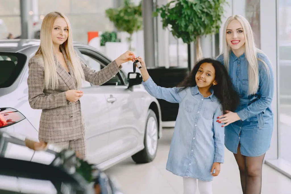 Woman buying the car. Little girl with mother. Manager with clients, lemonlawassist