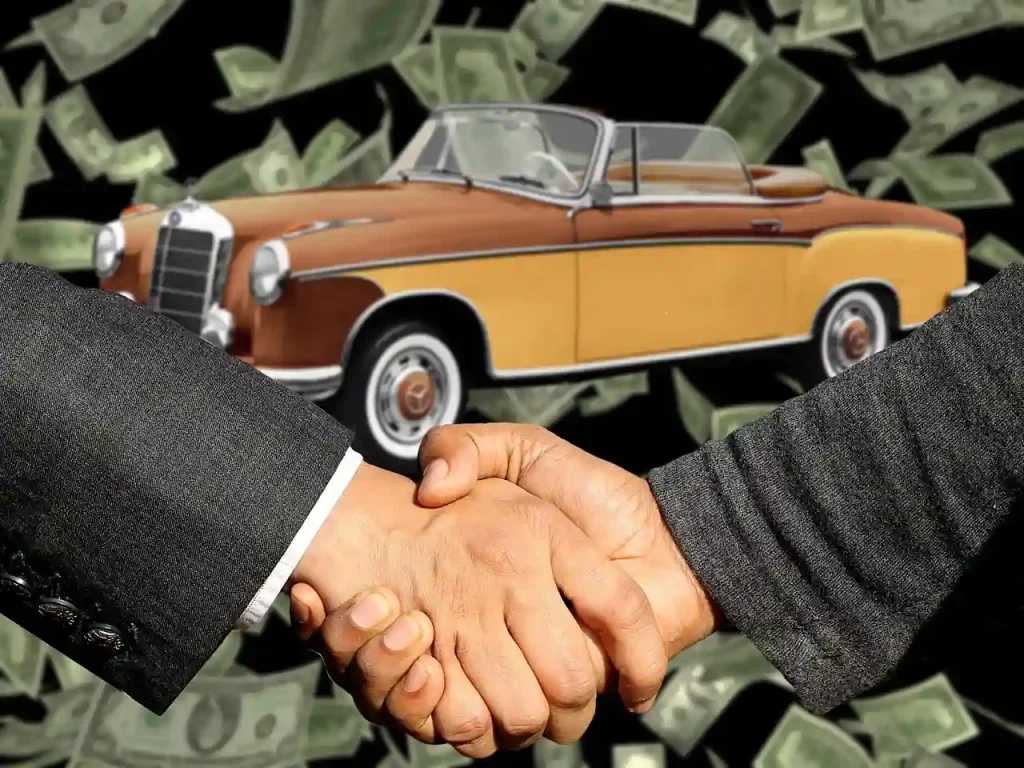 Handshake between two individuals in suits, with a classic car and floating dollar bills in the background, symbolizing a vehicle transaction, lemonlawassist