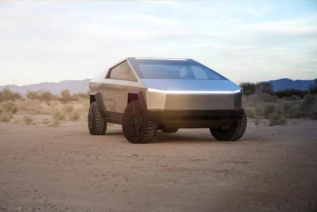 A futuristic, tesla cyber truck with a stainless steel body is parked in a desert landscape with mountains in the background during sunset, lemonlawassist