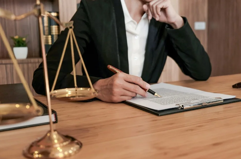 Close-up of a legal professional reading paperwork in a law office setting, lemonlawassist