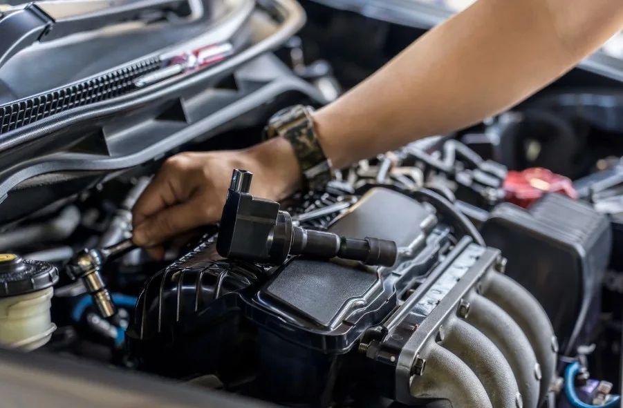Close-up of car mechanic working on engine repair in an auto workshop, lemonlawassist
