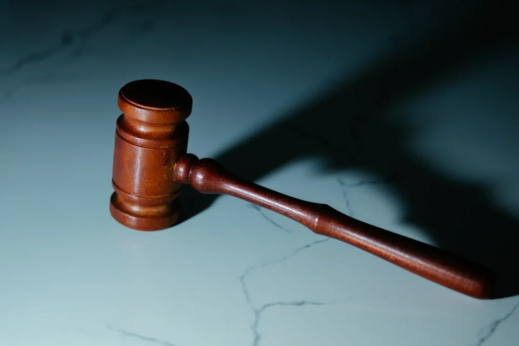 Wooden judge’s gavel on a marble surface under dramatic lighting, lemonlawassist