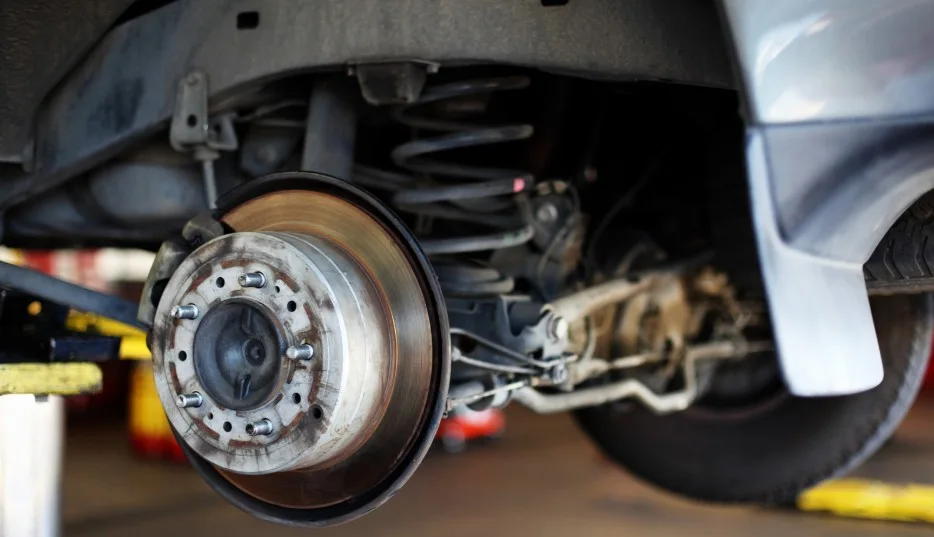 Close-up of a car brake assembly being inspected for potential lemon law issues, lemonlawassist
