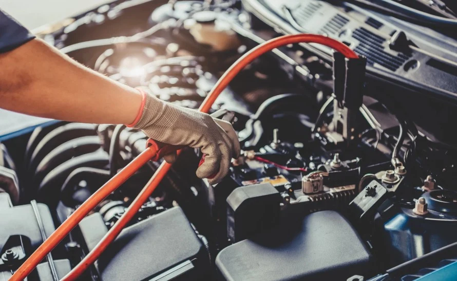 Mechanic jump-starting a car, showing common vehicle defects addressed by Lemon Law Assist’s legal team.