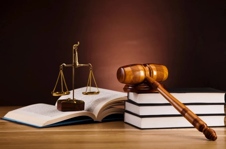A gavel, legal books, and a scale of justice, representing legal action and the pursuit of justice for consumers facing Lemon Law issues.