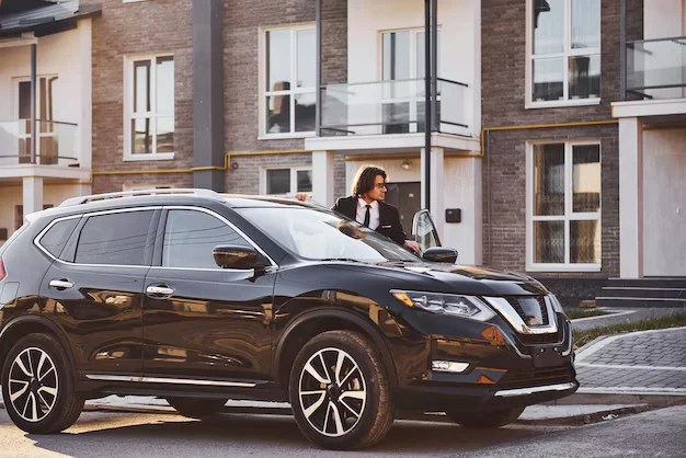 Man with new black SUV, suggesting potential Lemon Law scenarios for new car owners.